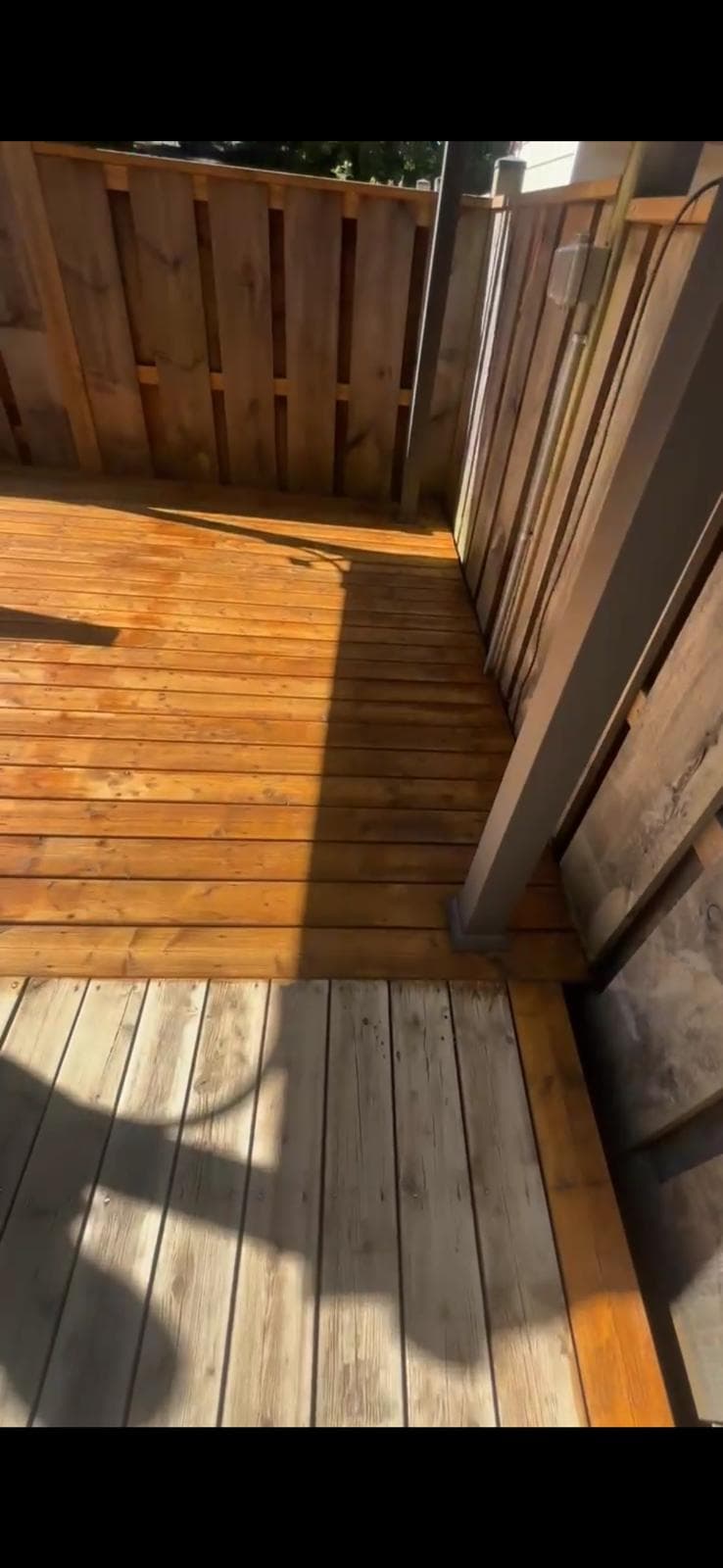 Close view showing stained and unstained sections of deck boards