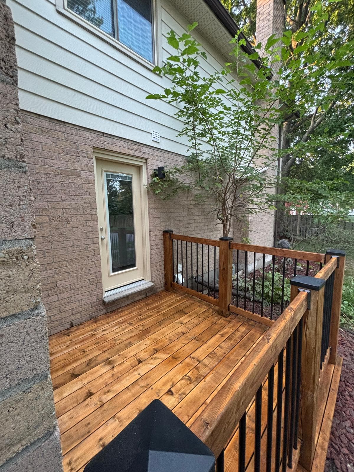 Completed stained side landing with wood railing and black balusters